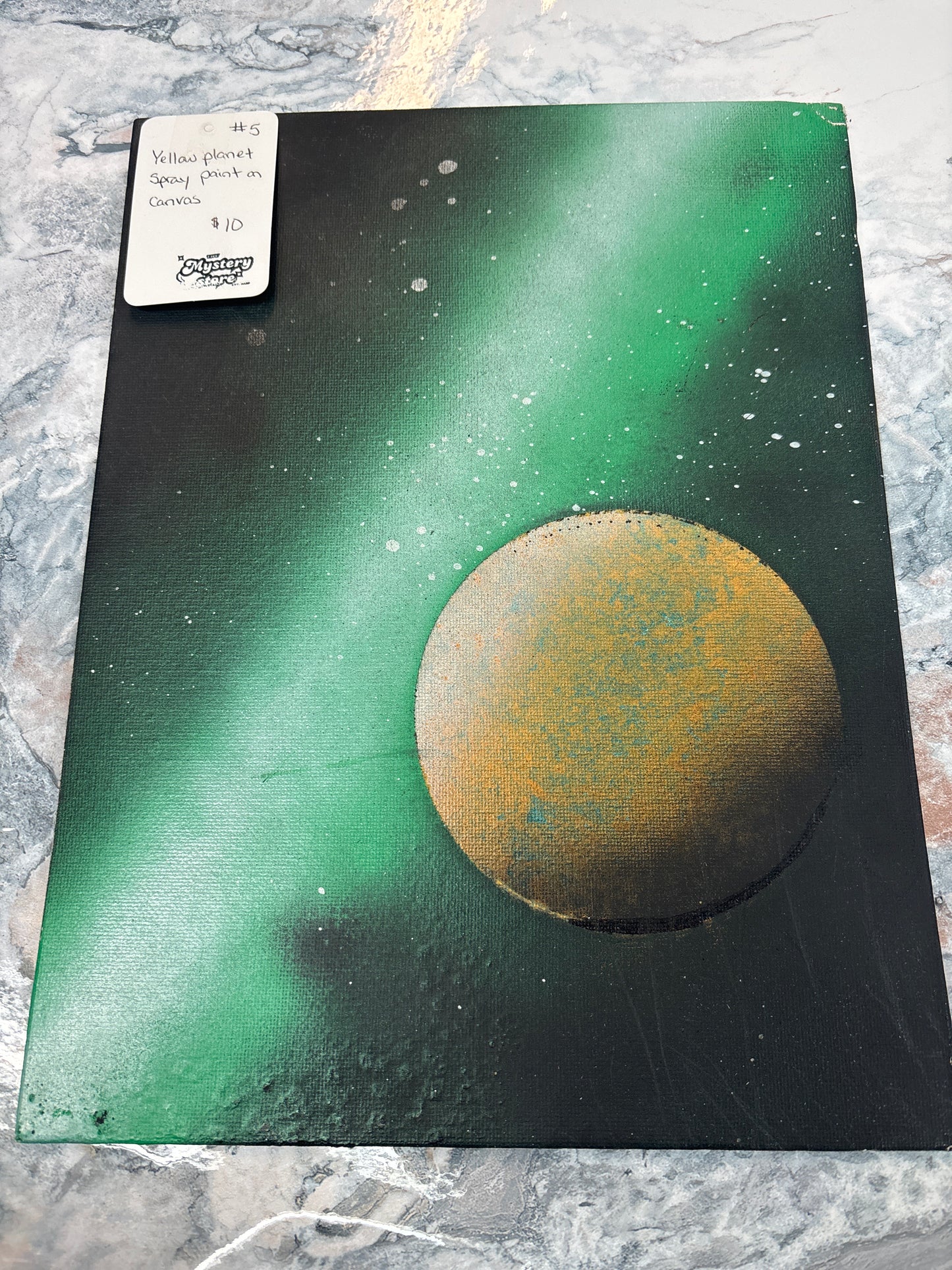 Yellow planet spray painted on canvas